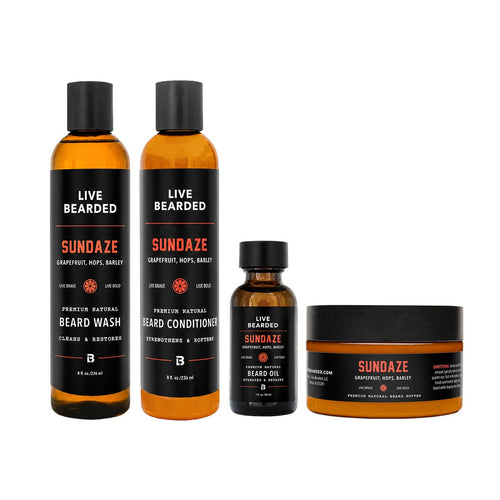 A 4-piece beard care set from Live Bearded, including two bottles of beard wash, one bottle of beard oil, and one jar of beard butter, all in amber glass with black caps and black labels.