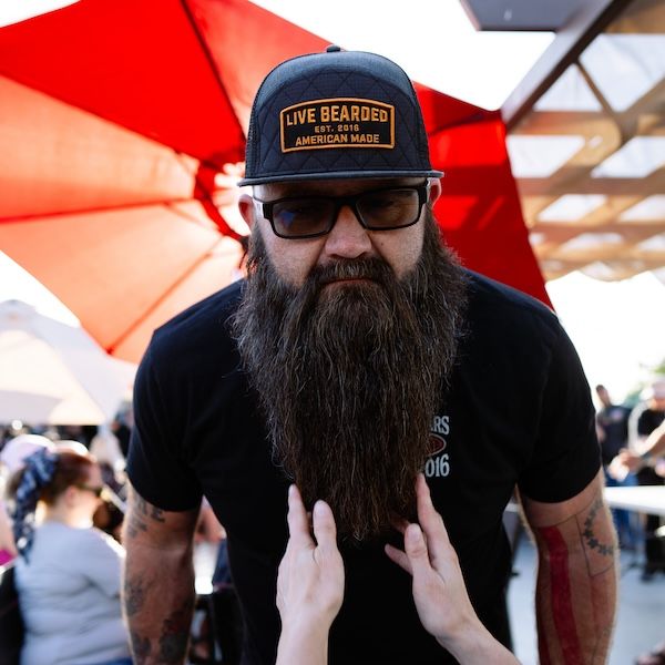 A real customer running a hand through a soft, healthy beard