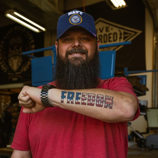 A real customer with a Live Bearded logo tattoo